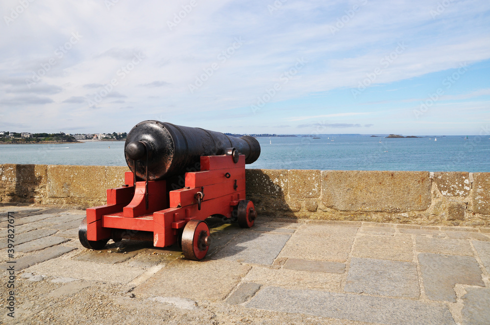 Obraz premium The old cannon is pointed towards the sea. Summer day, sea view. A cannon on a wooden gun carriage.