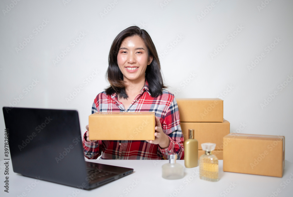 A young Asian businesswoman packing products in a package according to the order the customer has ordered.
A young Asian businesswoman packing products in a package according to the order the customer has ordered.