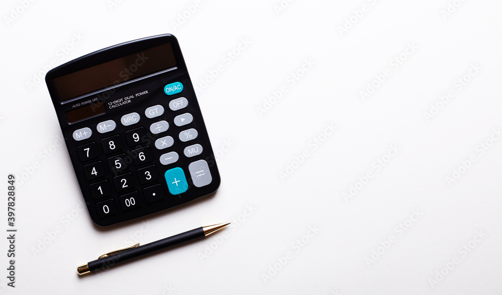 On a light background calculator and pen. Copy space. View from above On a light background calculator and pen. Copy space. View from above