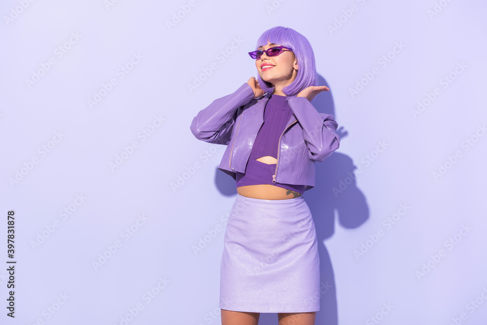 smiling young woman dressed in doll style on violet colorful background smiling young woman dressed in doll style on violet colorful background