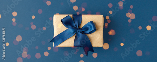 Blue theme craft gift box present with classic blue ribbon and copy space, holiday, xmas, christmas 2020. Shopping, sale banner, flyer, coupon concept, father, dad day, birthday, valentine, wedding