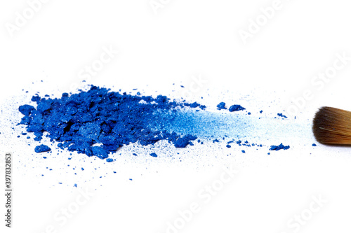 Brush with heap of blue eye shadow on a white background.