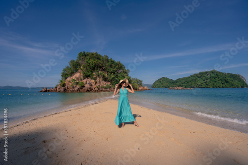 happy woman in maxi dress stading on sandbar beach of Phak Bia island travel destination in Krabi, Thailand photo