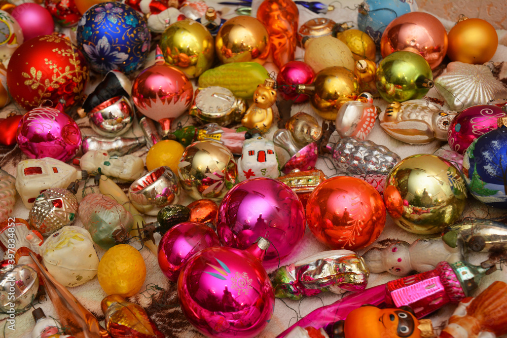 A view of bright pink, yellow, green, blue Christmas tree baubles, New Year's glass balls, spheres,  vintage, antique, old-fashioned and new, modern Christmas ornaments. Christmas toys background.