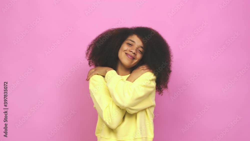 Young african american curly woman hugs, smiling carefree and happy Young african american curly woman hugs, smiling carefree and happy