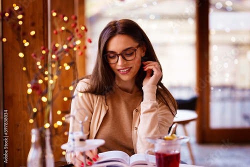 Confident woman reading a book while sitting in the cafe