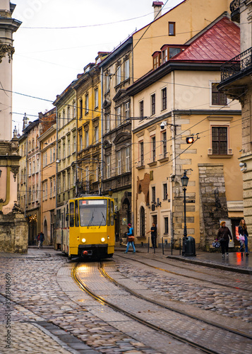 yellow tram in old street in the city, architecture of European town, vintage road