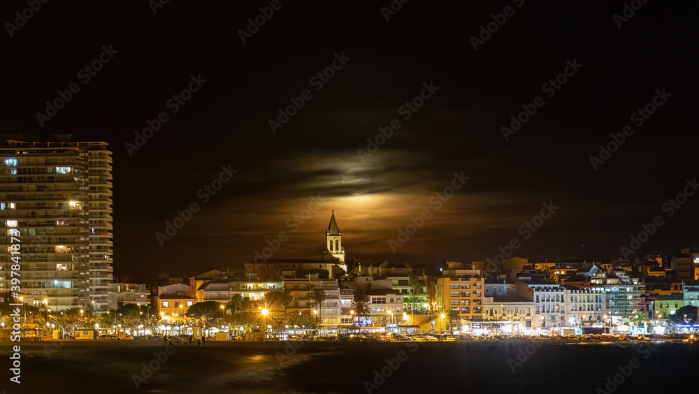 Night shot with full moon behind the clouds,town Palamos in Spanish Costa Brava , Catalonia