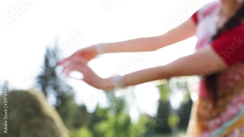 Blurred Indian dancing movements of hands with sun flares