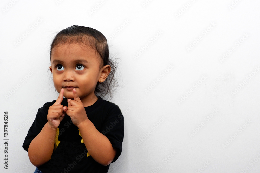 Little girl expression wearing a black t-shirt isolated on white background.