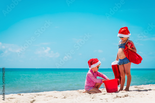 cute little girls celebrating christmas on tropical beach photo