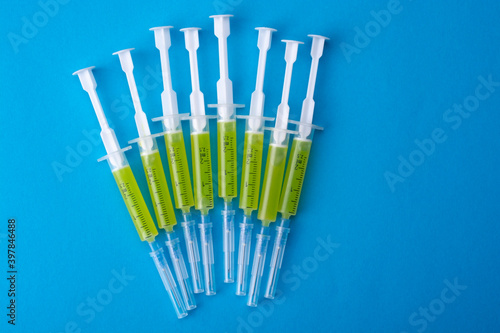 Several syringes with a vaccine on a blue background. View from above.