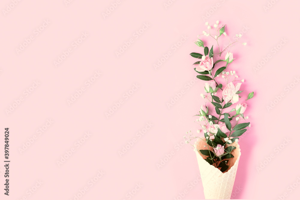 Beautiful flowers in ice cream cone on pink background