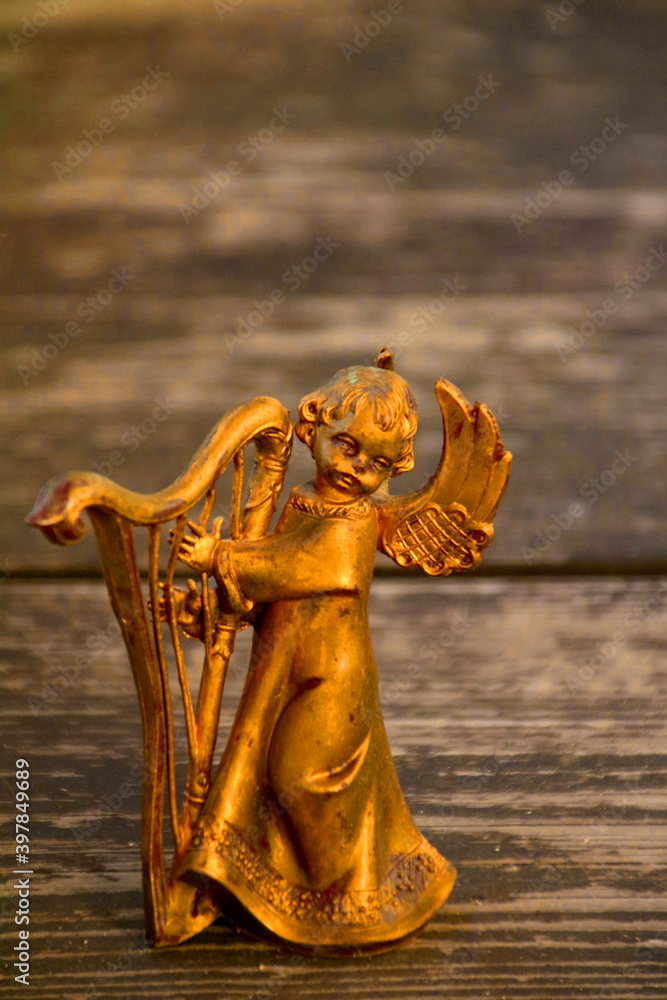 goldener engel spielt harfe