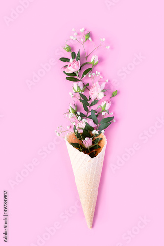 Beautiful flowers in ice cream cone on pink background © EkaterinaVladimirova
