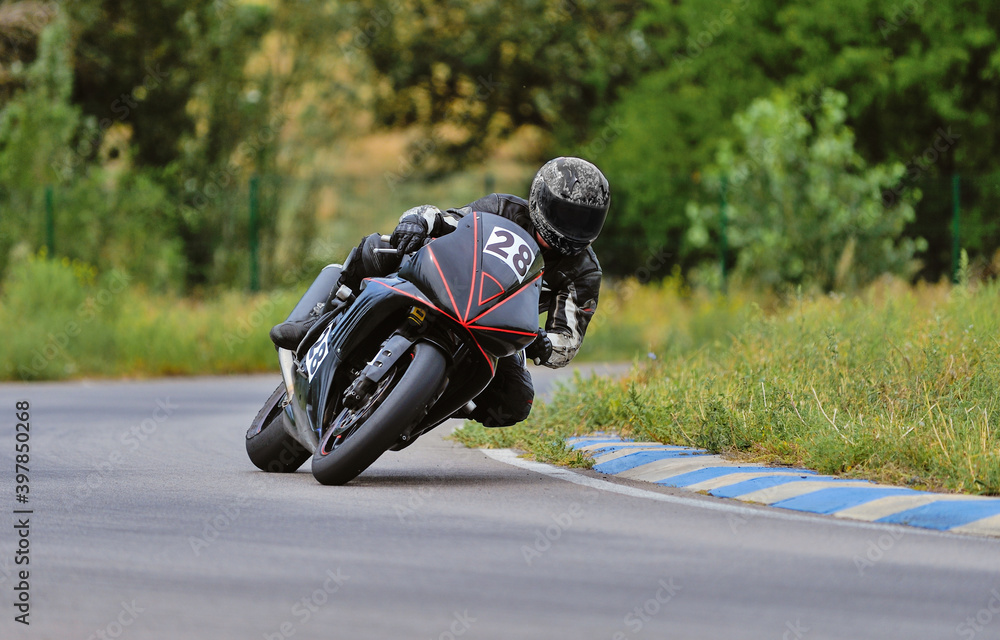 Motorcycle practice leaning into a fast corner on track Motorcycle practice leaning into a fast corner on track