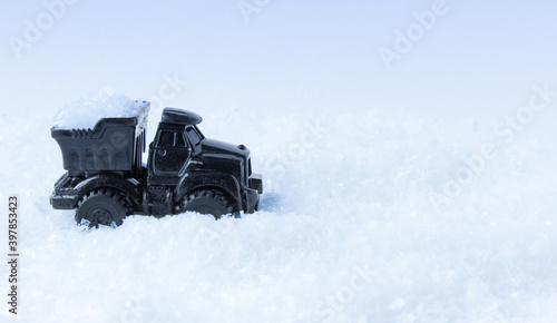 Truck toy black color carries in the body the snow.