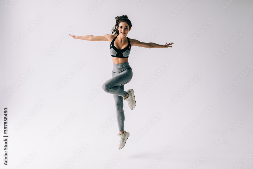 Fitness young woman jumping excited isolated on white background.