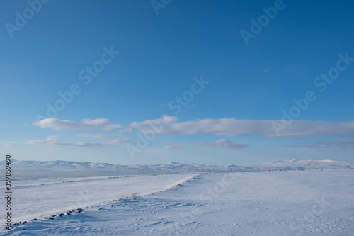 snow covered road at winter sunny day © MBAYSAN