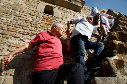 gruppo di anziani signori sia iuta prendendosi la mano , nello scale i gradini di un antico edificio photo
