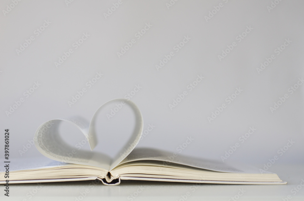 Obraz premium Close-up of book pages folded into a heart shape. Love of reading.