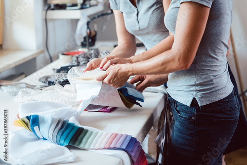 Designers inspecting sample fabric in atelier