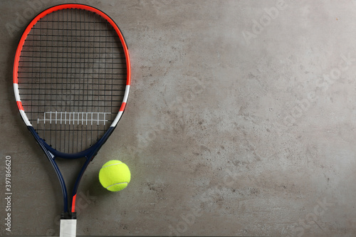 Tennis racket and ball on grey table, flat lay. Space for text © New Africa