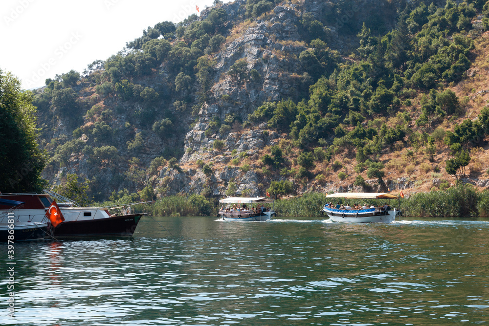 A small boats in a body of water with a mountain in the background