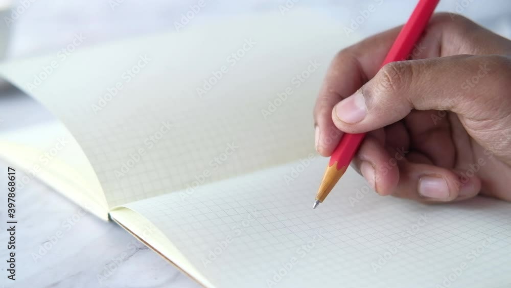 Close up of man hand writing with pencil on notepad. Close up of man hand writing with pencil on notepad.