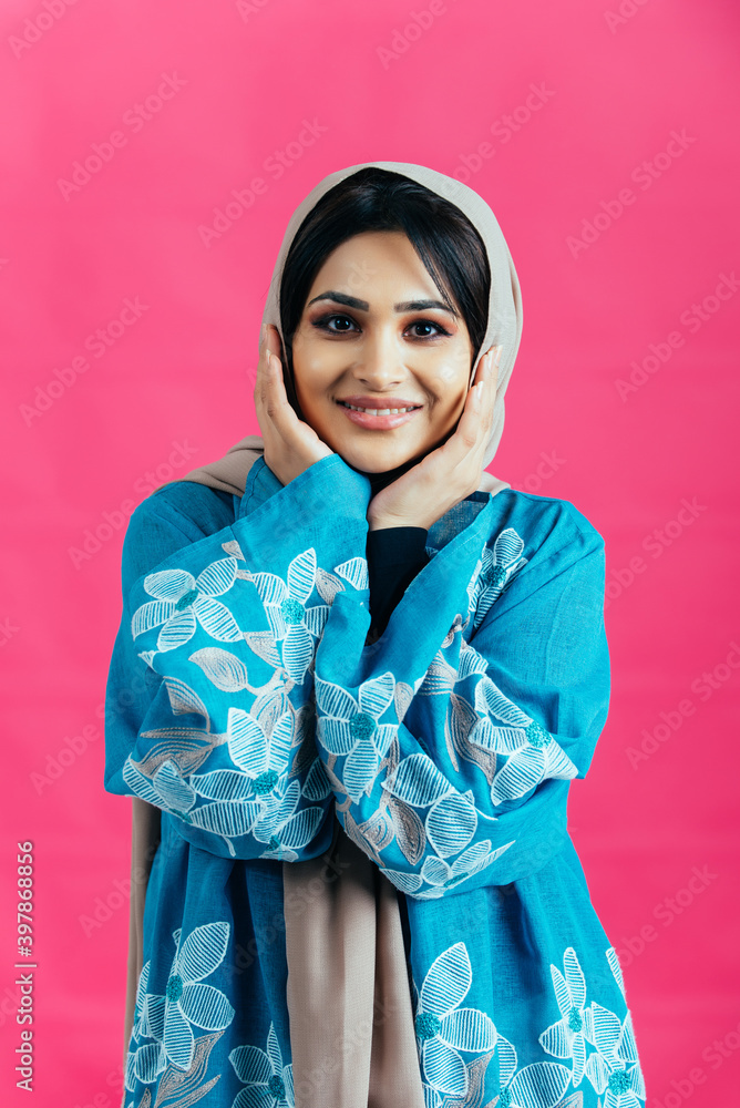 Beautiful woman from Dubai posing on colored background with traditional abaya Beautiful woman from Dubai posing on colored background with traditional abaya