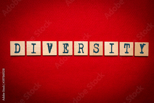 Wooden cubes with the word DIVERSITY on a red background. Concept of equality and equality for people, diversity.