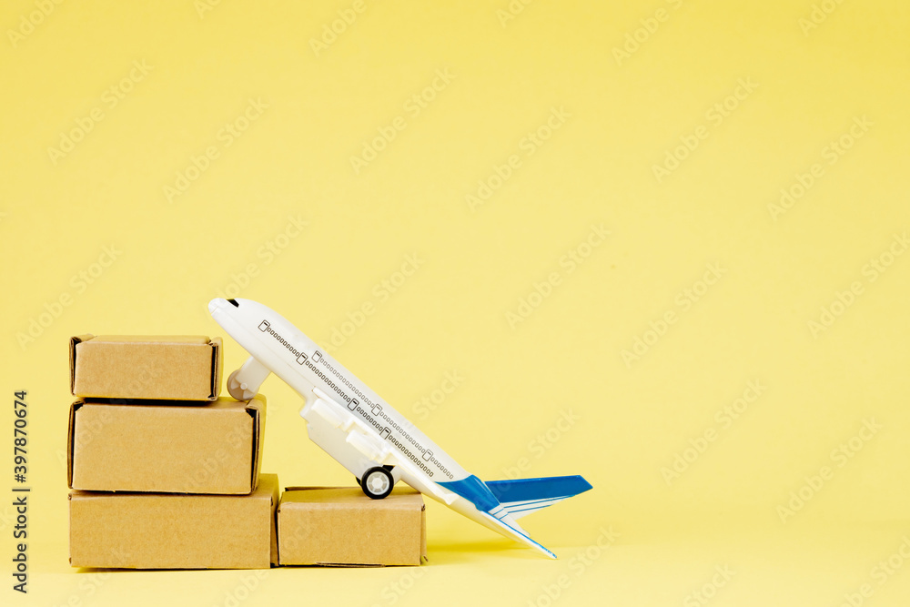 Airplane and stack of cardboard boxes. concept of air cargo and parcels, airmail. Fast delivery of goods and products. Cargo aircraft. Logistics, connection to hard-to-reach places. Banner, copy space Airplane and stack of cardboard boxes. concept of air cargo and parcels, airmail. Fast delivery of goods and products. Cargo aircraft. Logistics, connection to hard-to-reach places. Banner, copy space