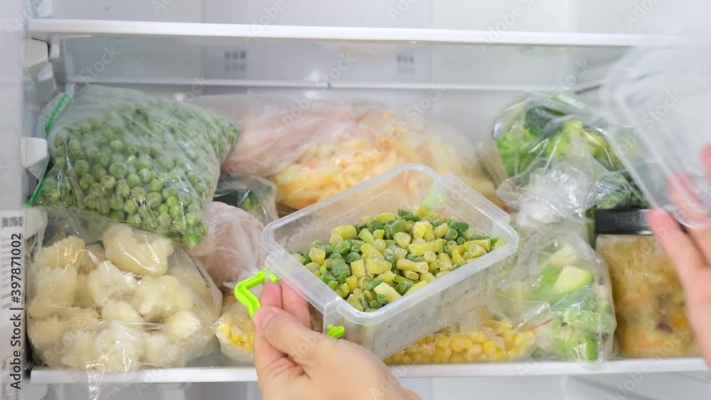 Frozen green beans. Frozen food storage. Home stock shelf. A raw food diet. Plastic boxes and bags with sliced vegetables and fruits