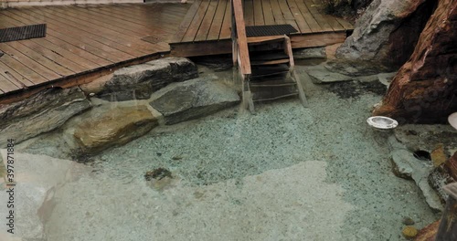 Gorgeous outdoor hot tub built into the rocks with a patio surrounding it at an amazing spa in Montpellier Quebec. photo