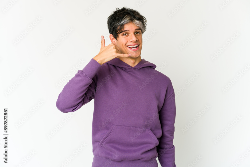 Young skinny hispanic man showing a mobile phone call gesture with fingers. Young skinny hispanic man showing a mobile phone call gesture with fingers.