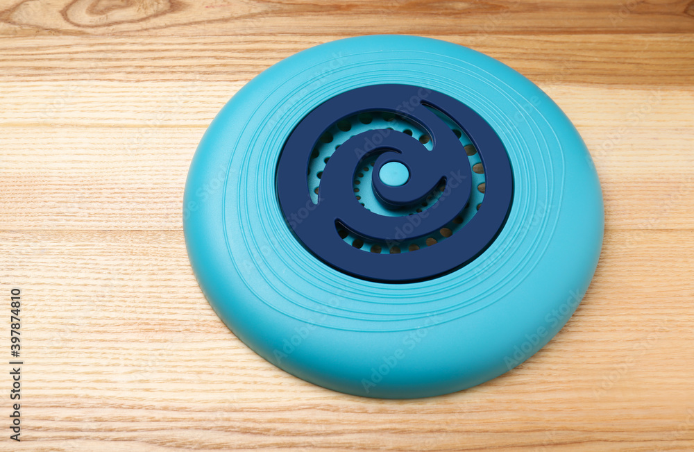 Blue plastic frisbee disk on wooden background Blue plastic frisbee disk on wooden background