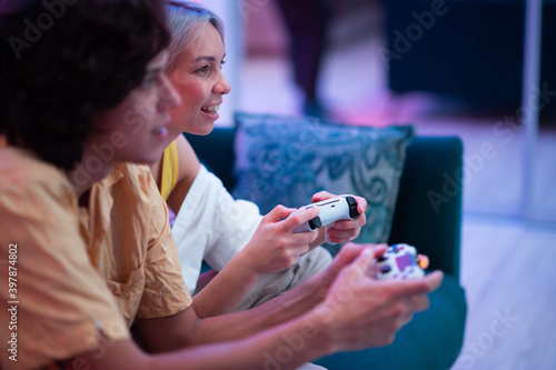 Smiling couple holding gamepads playing video game at home. Young people spending time together during self isolation on pandemic.