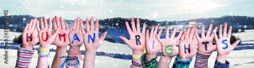 Children Hands Building Colorful English Word Human Rights. Snowy Winter Background With Snowflakes