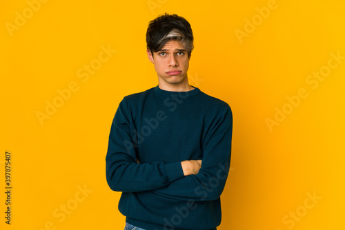 Young skinny hispanic man blows cheeks, has tired expression. Facial expression concept.