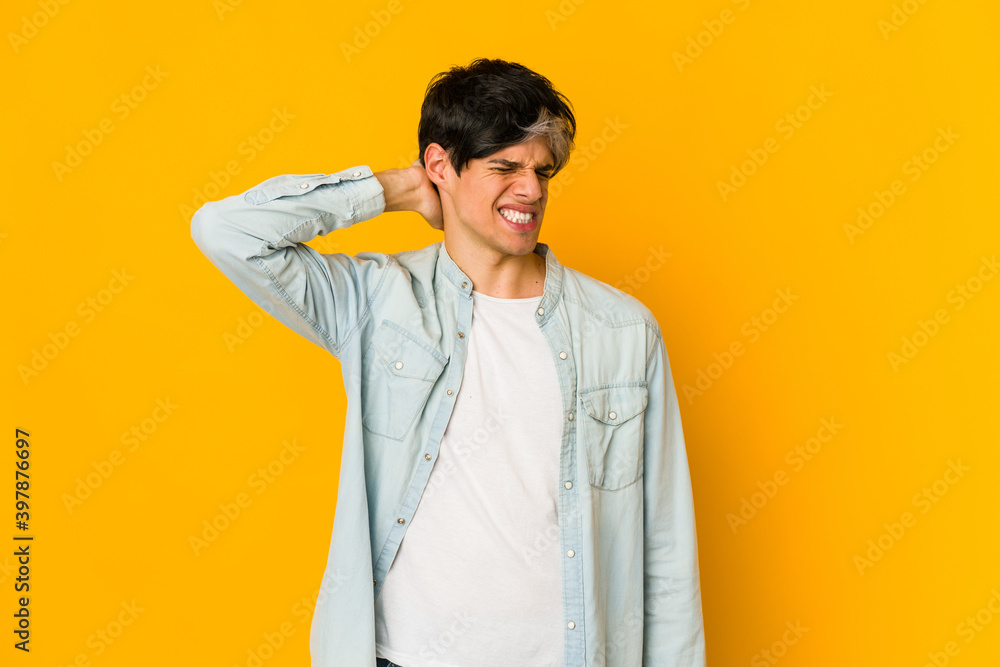 Young skinny hispanic man suffering neck pain due to sedentary lifestyle.