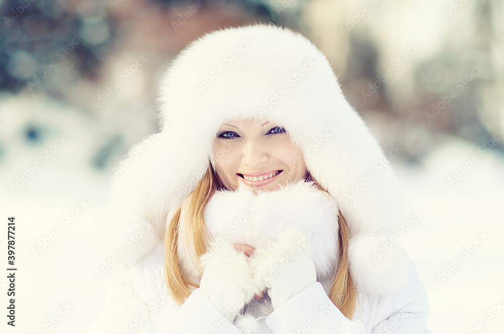 Winter portrait of beautiful smiling woman with snowflakes in white furs Winter portrait of beautiful smiling woman with snowflakes in white furs
