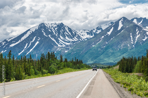 Car on Alaskan Road in Summer headed to Mountains 