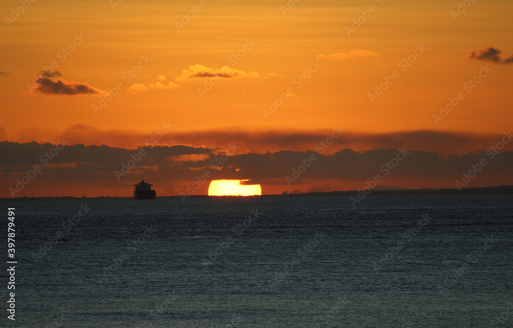 fantastic sunset on the ocean horizon next to ship