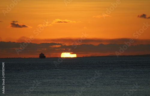 fantastic sunset on the ocean horizon next to ship