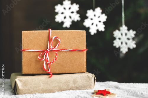 Gifts in craft paper. A Christmas gift. Winter composition. White snowflakes. New Year. Gift close up
