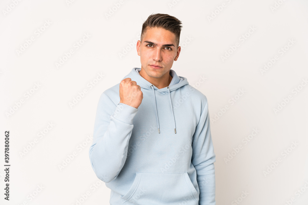 Young caucasian handsome man isolated showing fist to camera, aggressive facial expression. Young caucasian handsome man isolated showing fist to camera, aggressive facial expression.