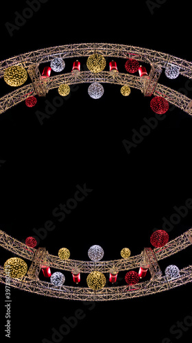 Christmas abstract symmetry frame arch shape decoration object colorful toys and garland lamps on black background empty copy space for your text here vertical picture