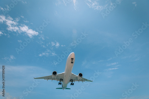 White airplane photographed from below is flying in clear blue sky, The fastest way to travel. Time saving