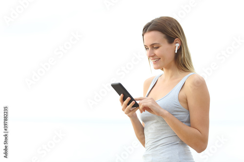 Teen listening to music with wireless earphones on the beach