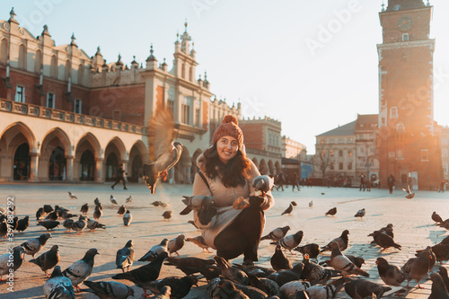 Canvas Print Young woman and pigeons in Market Square, Krakow, Poland